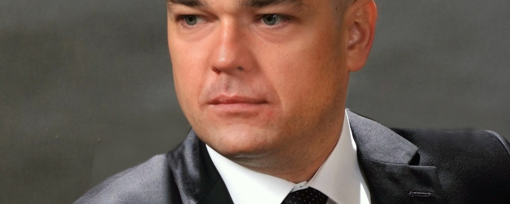 zdjęcie solisty Mariusza Budkowskiego na szarym tle